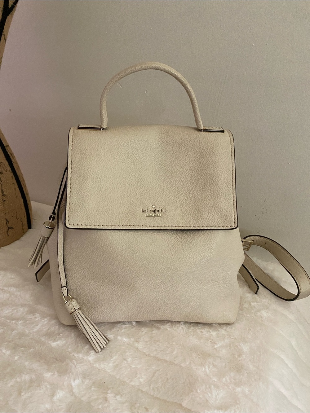 Kate Spade New York Naomi Leather Flap Backpack in an ivory colorway